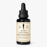Black dropper bottle with a beige label reading "Aphrodite's Passion Lustrate Oil" on a white background