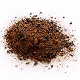 Pile of ground herbs and roots (Chai Guy: Black Tea Blend) on a white background