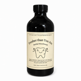 Black bottle of 'Fresher than You Are' herbal mouthwash on a white background