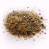 Pile of dried herbs (Zeus' Zest: Green Tea Blend) on a white background