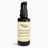 Black bottle labled snowbrush skin oil on a white background